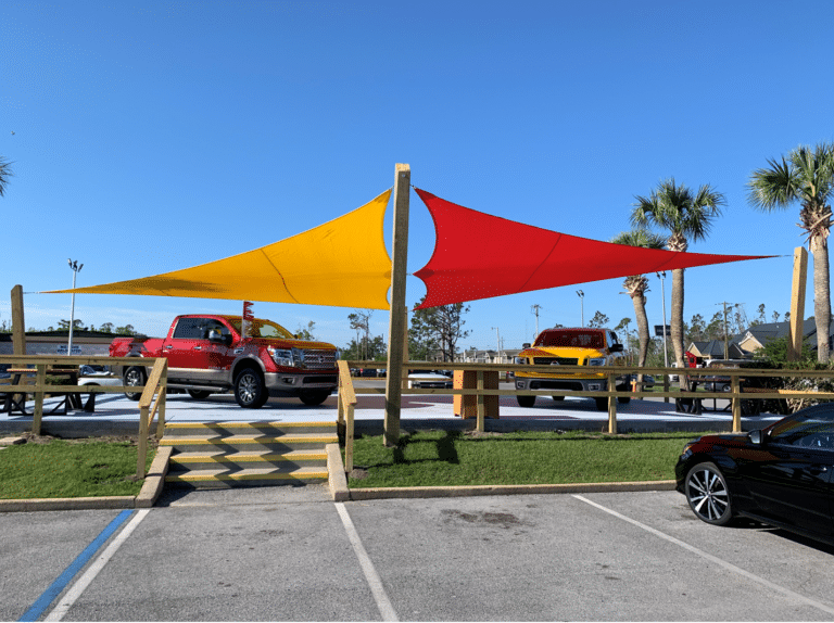 Shade Sais shading a car company in Ft Walton Beach for commercial & residential outdoor spaces | We Can Shade It services Pensacola, Destin, Fort Walton Beach, 30a, Panama City Beach, Panama City, Mexico Beach, Tallahassee and all surrounding cities with Shade Sail Designs & Installation, Artifcial lawns & turf pads, sports netting, safety features & more.